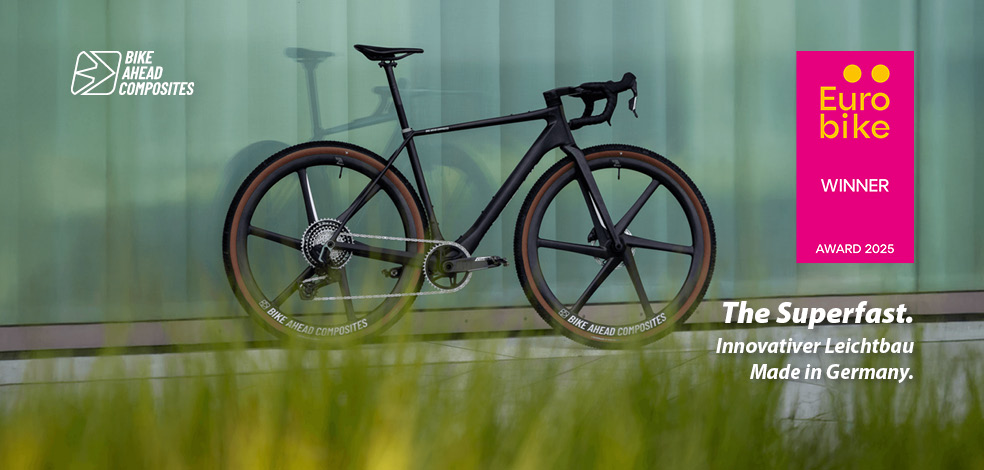 Ein schwarzes Gravel Bike lehnt an einer Wand.