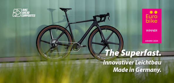 Ein schwarzes Gravel Bike lehnt an einer Wand.