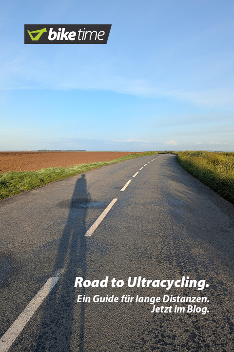 Ulreacycling – Ein Guide für Lange Distanzen. Jetzt im Blog. Der lange Schatten eines Radfahrer fällt in der Abendsonne auf eine Straße, die sich bis zum Horizont zieht.