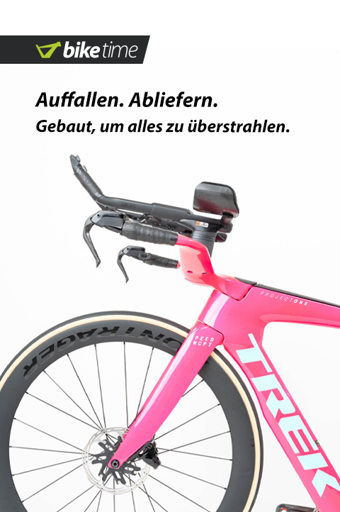 Trek SpeedConcept Custom: Auffallen. Abliefern. Gebaut, um alles zu überstrahlen. Der vordere Teil eine Triathlon-Fahrrads ist zu erkennen. Das Bike ist in einem markanten pinken Farbton gehalten. Die Wortmarke Trek ist in hellblau.