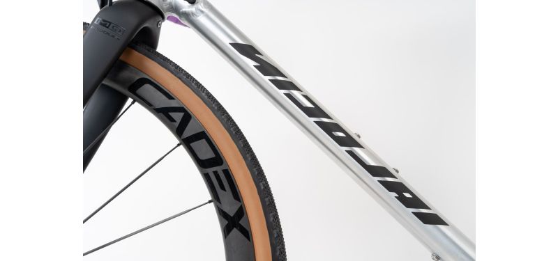 Eine Nahaufnahme von einem Fahrrad ist zu sehen. Der Bildausschnitt zeigt den Aluminium Rahmen und einen Teil vom vorderen Laufrad.