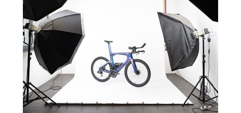 Ein blaues Triathlon-Fahrrad steht in einem Fotostudio.