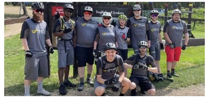 Gruppenfoto mehrerer Menschen, die alle ein Biketime-Trikot tragen.