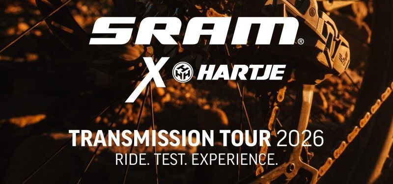 Im Hintergrund sind Teile des Antriebes eines Fahrrads zu erkennen. Im Vordergrund die Wortmarke SRAM und Hartje mit Hinweis auf die Transmission Tour.