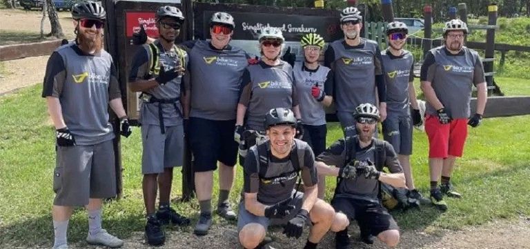 Gruppenfoto mehrerer Menschen, die alle ein Biketime-Trikot tragen.