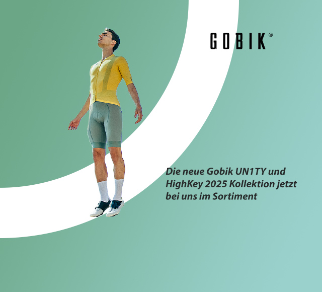 Ein Mann in voller Radsportkleidung, gelbes Trikot, türkise Bib-Short und schwarz-weiße Schuhe. Der Mann wirkt wie schwerelos.