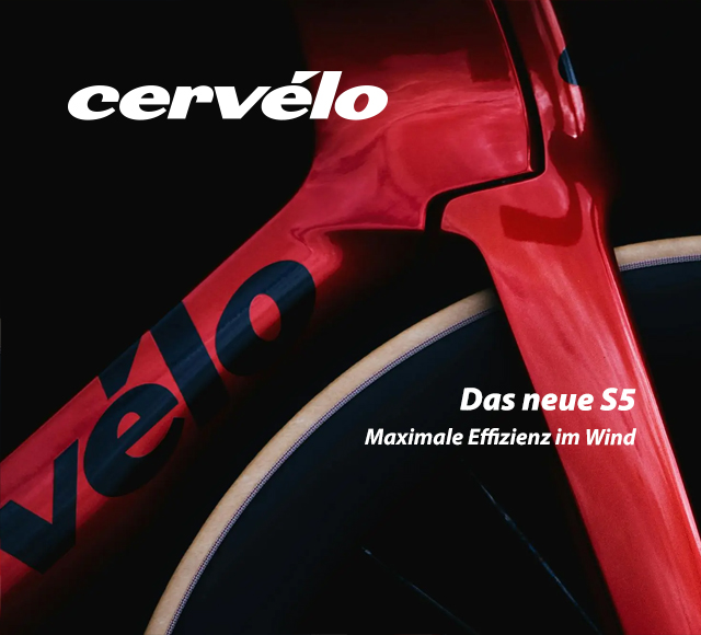 Ein Teil eines Fahrradrahmens in rotem Farbton ist zu erkennen. Es ist ein Detailbild nahe des Vorderrads. Zu erkennen sind Teile des Unterrohres und der Gabel. Außerdem Teile der Wortmarke cervelo.