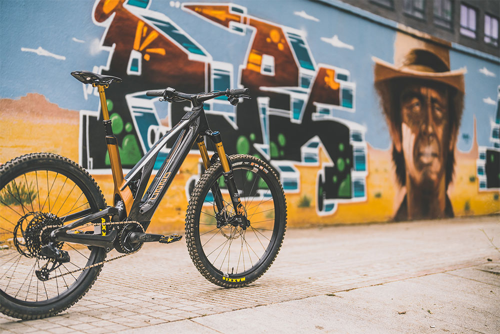 Ein Unno Fahrrad steht vor einer Wand mit Graffiti.