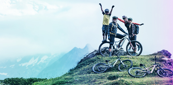 Vier Menschen stehen mit Fahrrädern auf einem Berg.