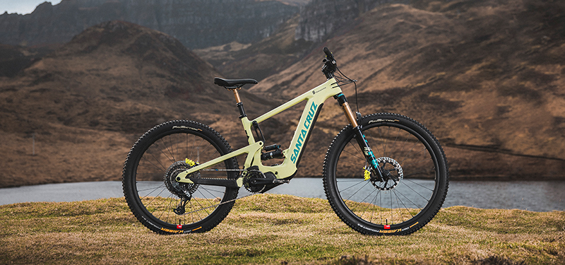 Santa Cruz Heckler 2022 in Gloss Avocado Green in der rechten Seitenansicht vor einem Fluss und bergiger Landschaft.